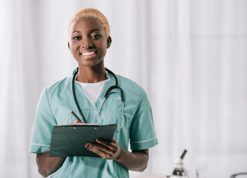 smiling african american woman with stethoscope and clipboard