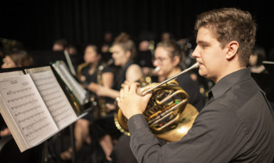 The UWF Symphonic Band music ensemble performing on the Mainstage Theatre in the Center for Fine and Performing Arts