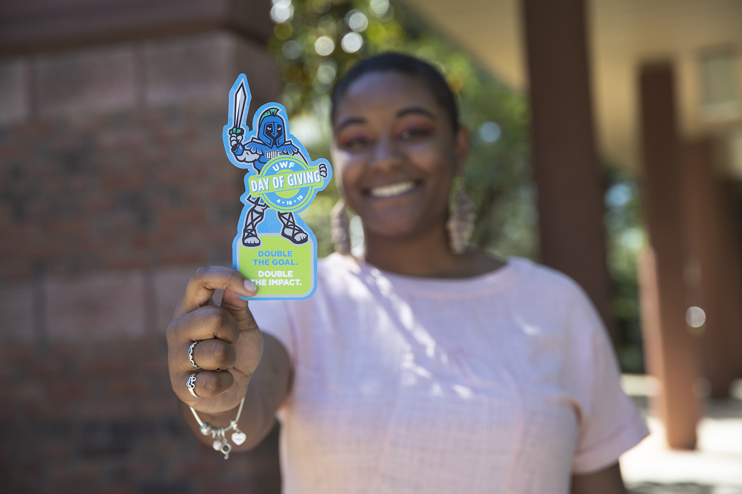 UWF student holds Argie cut-out in honor of Day of Giving during UWF Founders Week