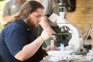Stephen Buchanan a UWF marine biology student prepares a microscope slide for visitors to look at phytoplankton during the BioBlitz species identification and Biodiversity Festival at the Gulf Islands National Seashore.