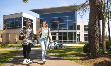 UWF students pass the College of Business on their way to class.