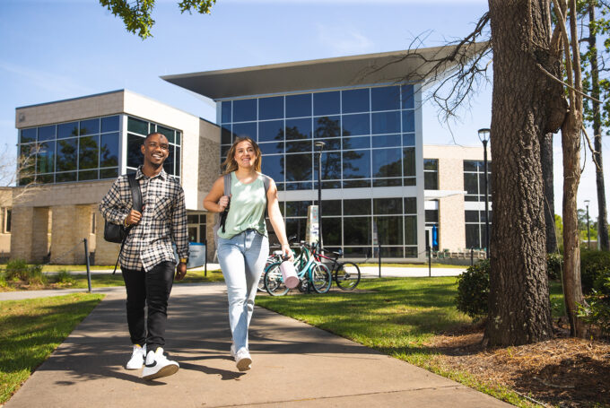 UWF students pass the College of Business on their way to class.