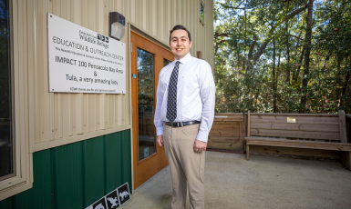 UWF graduate James Barnes stands in front of Emerald Coast Wildlife Rescue Education and Outreach Center