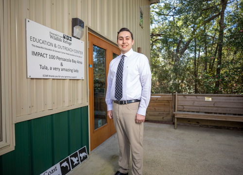 UWF graduate James Barnes stands in front of Emerald Coast Wildlife Rescue Education and Outreach Center
