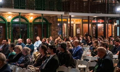 Guests sit in the audience at a lecture series at the Pensacola Museum of Commerce