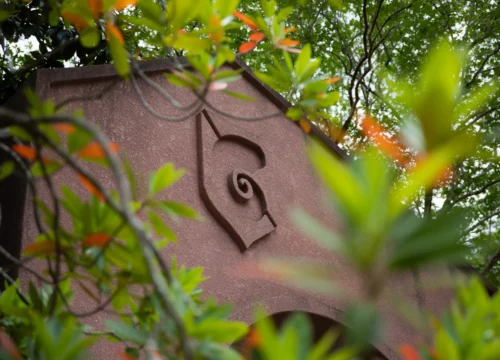 Archway with nautilus shell surrounded by greenery sprinkled with orange leaves