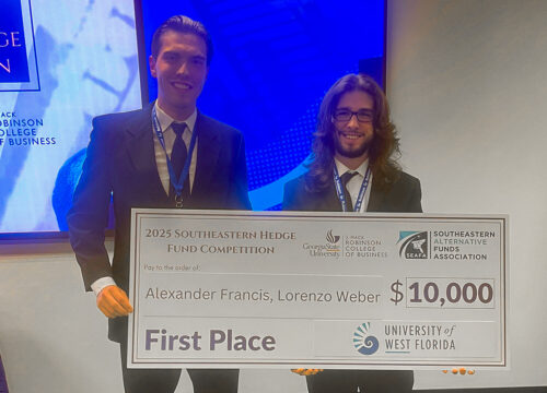 Two students hold a large check that reads, "2025 Southeastern Hedge Fund Competition. Georgia State University, J. Mack Robinson College of Business. Southeastern Alternative Funds Association. Pay to the order of: Alexander Francis, Lorenzo Weber. $10,000. First Place. University of West Florida.