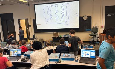 Kids in a lecture hall learning robotics