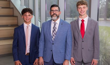 UWF Interim President Diaz stands between two National Merit Finalists