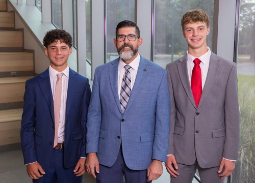 UWF Interim President Diaz stands between two National Merit Finalists