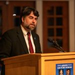 Photo: Person speaking at a podium with a microphone