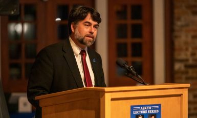 Photo: Person speaking at a podium with a microphone