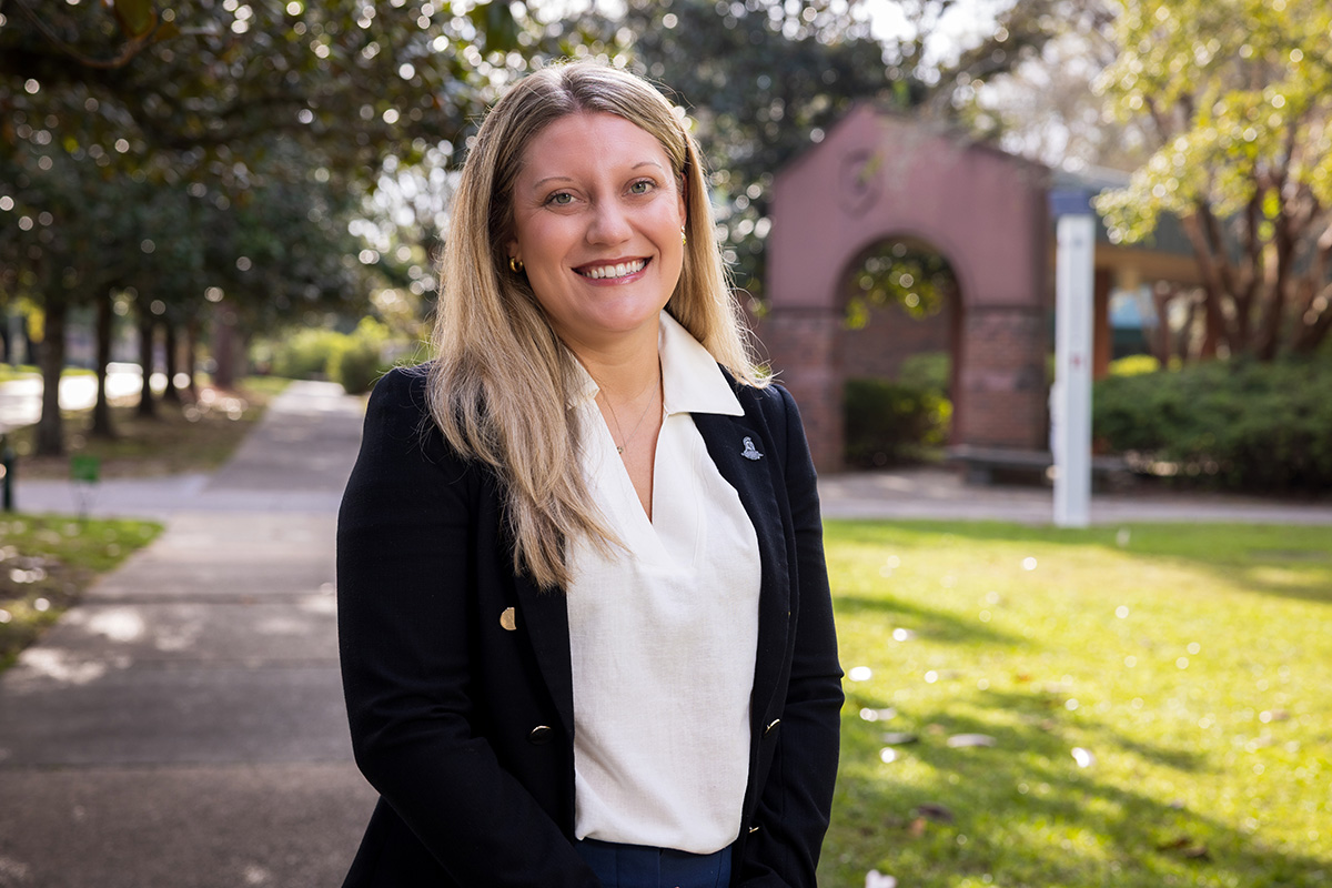 Tori Bennett smiles in front of UWF's Cantor Al Sol Archway