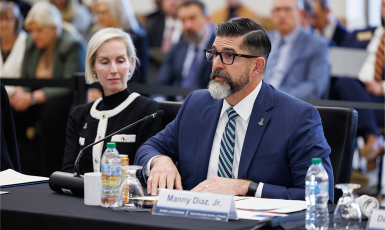Manny Diaz Jr. and Rebecca Matthews sit at a table at the Board of Governors meeting.
