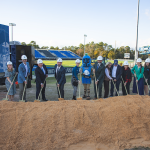 16 people and the Argonaut mascot hold shovels at the stadium groundbreaking
