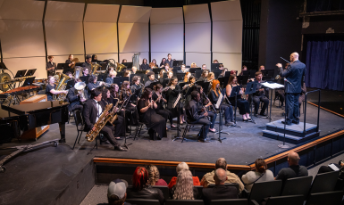 UWF symphonic band performs a concert on stage.