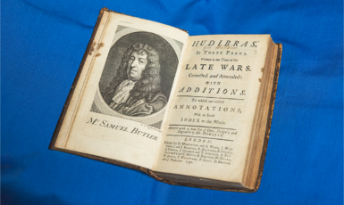 Vintage book sits open on a blue tablecloth.
