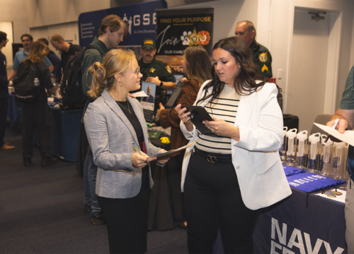 A student and employer interact at a career fair.