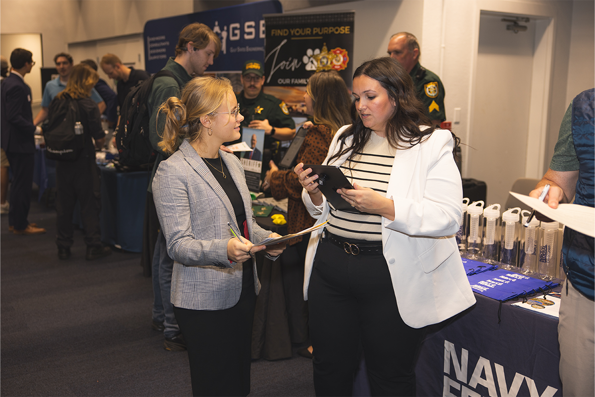 A student and employer interact at a career fair.
